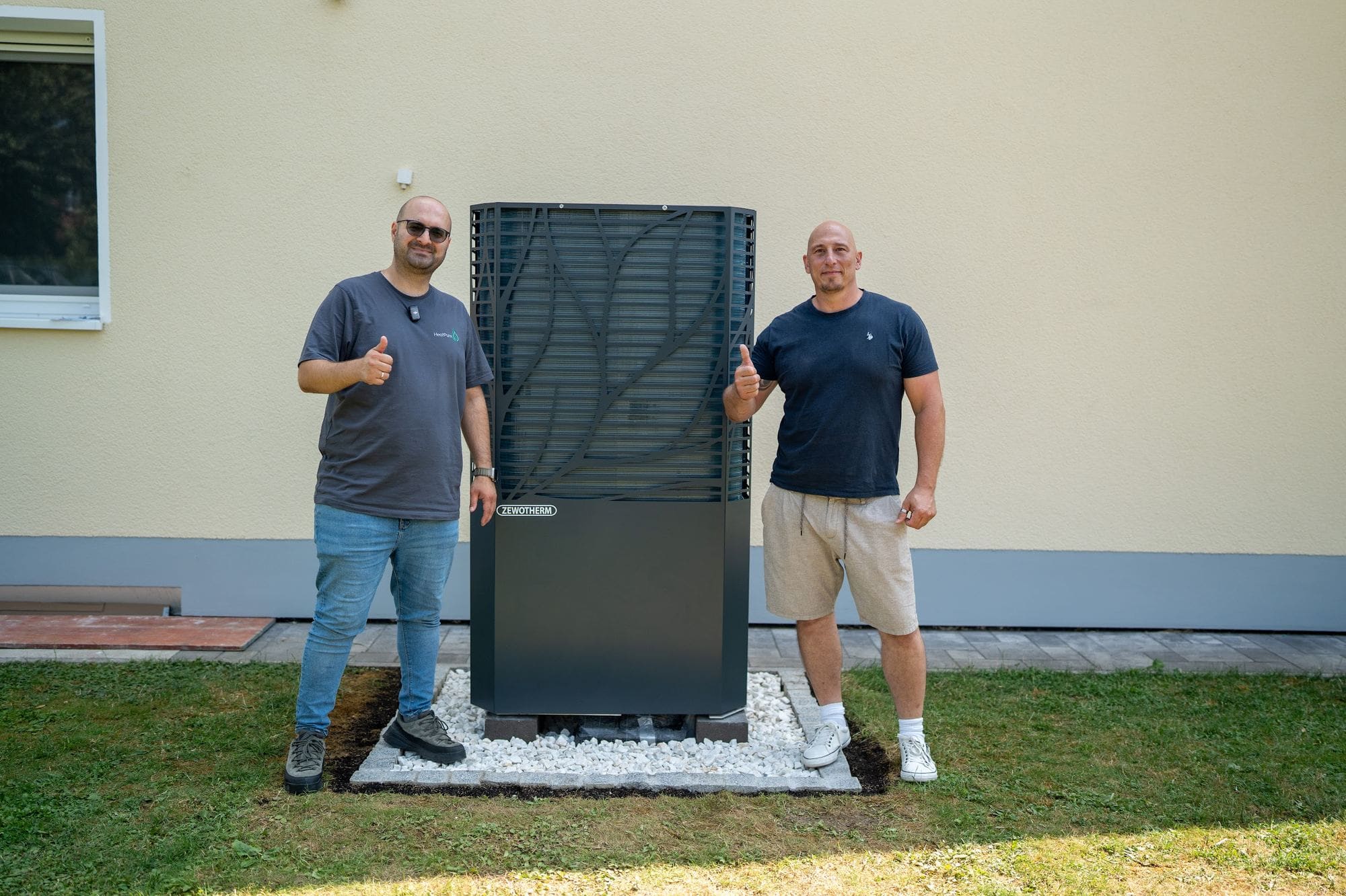 Kunde und Team von HeatPure vor einer neu installierten Wärmepumpe im Garten
